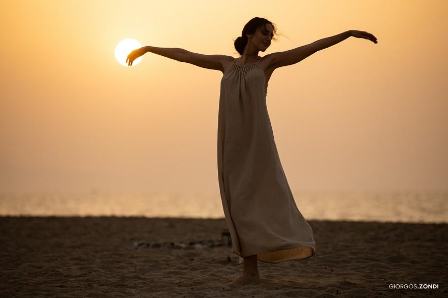 Lifestyle photo of a girl dancing at sunset on the beach of Nautilux Hotel, highlighting the beauty and freedom of a seaside evening.